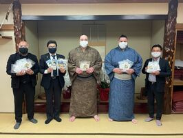 特製マスクを手にする栃ノ心(右から3人目)、倉谷社長(同4人目)ら