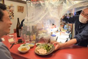常連客に料理を提供する星野さん(右)。昼はカレー、夜は予約制でおまかせ料理が楽しめる