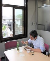 会社の打ち合わせ室で1人、テークアウトの弁当をつつく記者。自宅での反省を踏まえ、窓を開け換気に気を配る=21日午後、下野新聞社