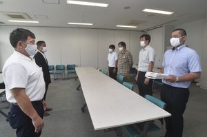 県高野連の藤田理事長（左）に嘆願書を手渡す保護者の有志＝23日午後２時55分、宇都宮工業高
