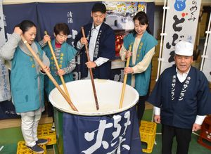 酒仕込み唄のリズムに合わせ、櫂棒を回すおかみら