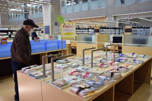 「黄ぶなぶっく！」コーナーに並べられた本を見る利用者