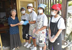 高齢者に弁当を配達する中学生たち